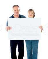 Husband and wife displaying advertising board