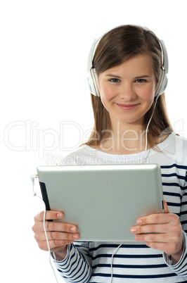 Beautiful girl listening to music via wireless tablet