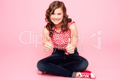 Pretty teenager showing double thumbs up