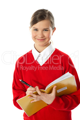 Happy young girl writing on notebook