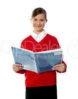 Charming school kid reading book