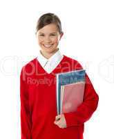 Cheerful schoolgirl holding books