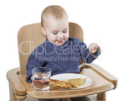 young child eating in high chair