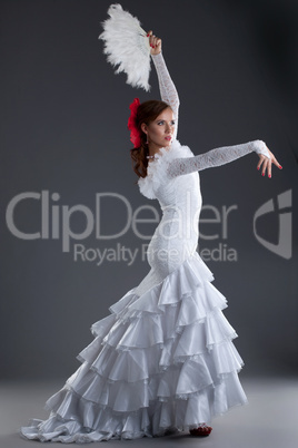 Young woman in white dress performing flamenco