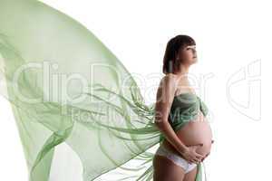Beautiful pregnant woman with blowing fabric