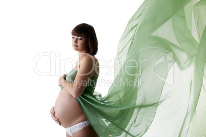 Beautiful pregnant woman with green blowing fabric