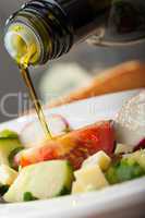Olivenöl über Salat gießen