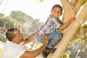 Happy Mixed Race Father Helping Son Climb a Tree