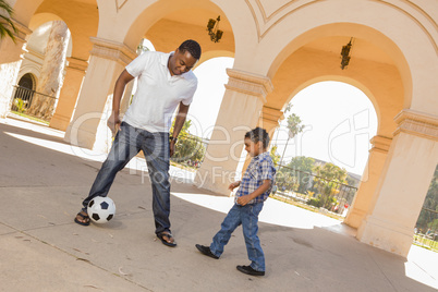 Mixed Race Father and Son Playing Soccer in the Courtyard