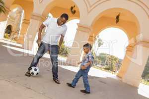 Mixed Race Father and Son Playing Soccer in the Courtyard