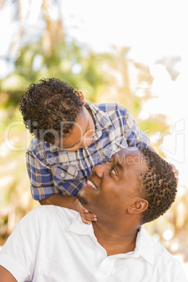 Mixed Race Father and Son Playing Piggyback in Park