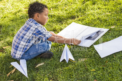 Mixed Race Boy Learning How to Fold Paper Airplanes