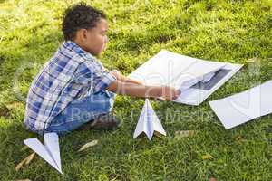 Mixed Race Boy Learning How to Fold Paper Airplanes