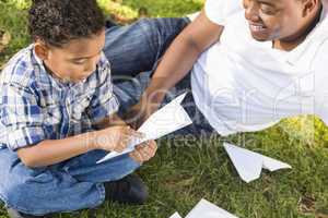 Mixed Race Father and Son Playing with Paper Airplanes