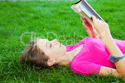 Teen girl reading the Bible outdoors