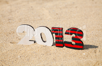 Wooden 2013 year number on the sand