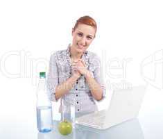 Junge Frau mit Laptop und Snack am Schreibtisch