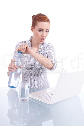 Junge Frau mit Laptop und Snack am Schreibtisch