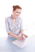 Junge Frau mit Laptop und Snack am Schreibtisch