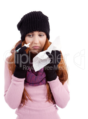 Frau mit Taschentuch und Nasenspray mit Grippe