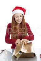 Junge Frau packt Geschenke für Weihnachten ein