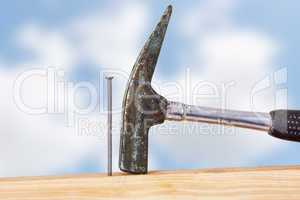 Hammer and nail with wooden board
