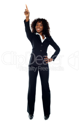 Smiling business executive pointing upwards