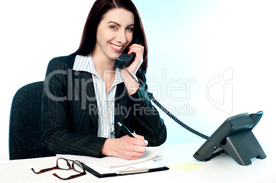 Operator receiving call on telephone and writing