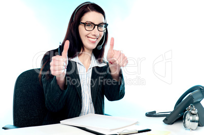 Call centre operator gesturing double thumbs up