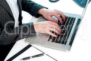 Females hands typing on laptop keypad. Cropped image