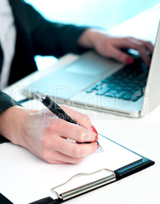 Closeup of woman copying data from laptop