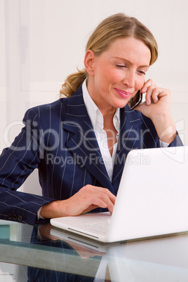 businesswoman in office with mobile and laptop