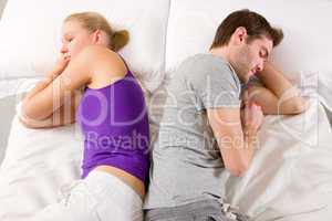 couple lying in bed back-to-back