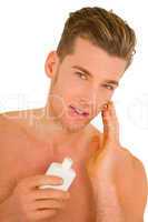 Young man applying aftershave