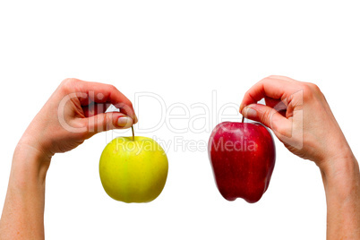 hands holding a yellow and a red apple