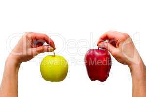 hands holding a yellow and a red apple