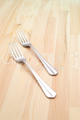 two fork on a pinewood table