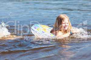 beautiful little girl floating in the water