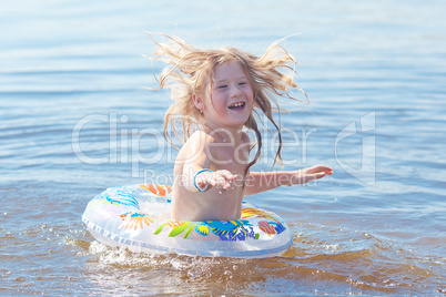 beautiful little girl splashes in the water