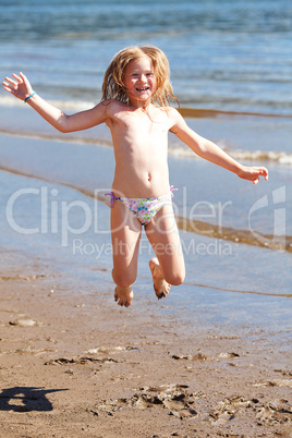 beautiful little girl jumping on the beach