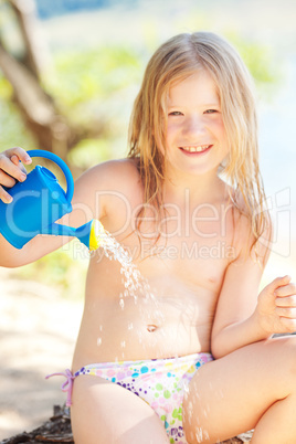 portrait of a beautiful little girl with a watering can