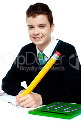 Boy doing homework with calculator beside him