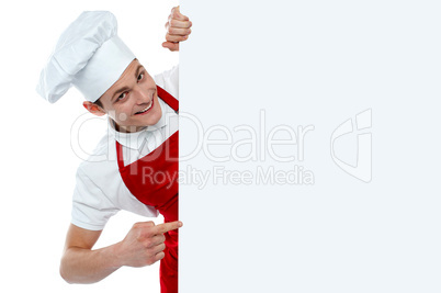Male chef indicating at blank menu