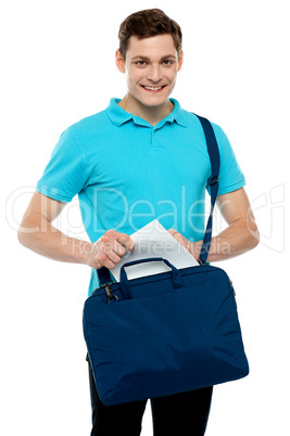 Guy taking out paper from his laptop bag