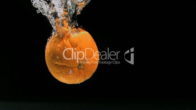 Orange fällt ins Wasser in Zeitlupe