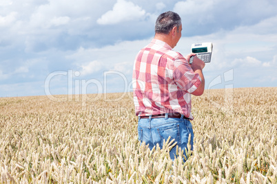 Farmer with computing machine in the field