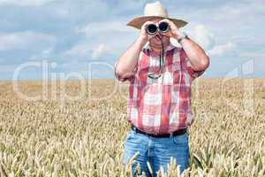 Man with binoculars in cornfield