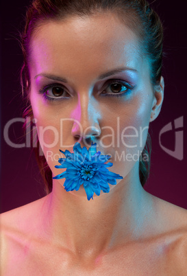 Beautiful woman with flower in mouth