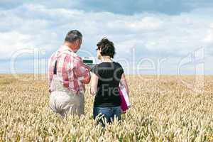 Farmer and agricultural engineer in the field discuss