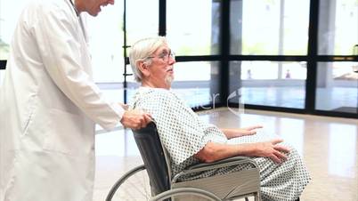 Patient in a wheelchair pushing by a doctor